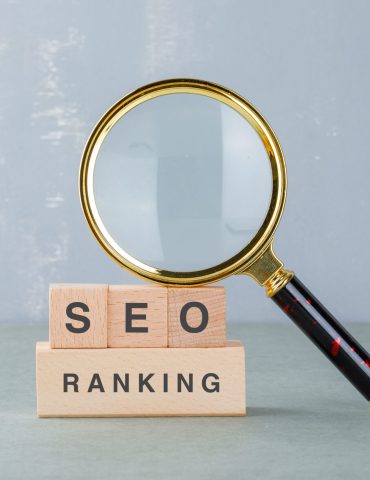 Conceptual of seo analysis and business. with wooden blocks with words on it, magnifying glass on sage color background side view. horizontal image